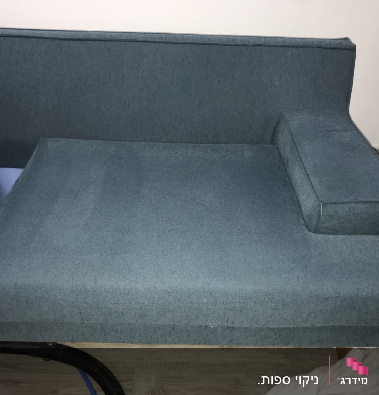 ספה כחולה עם צינור ניקוי על הרצפה